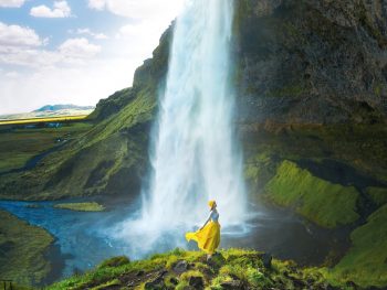 standing on a rock beside the walking path around the Seljalandsfoss waterfall