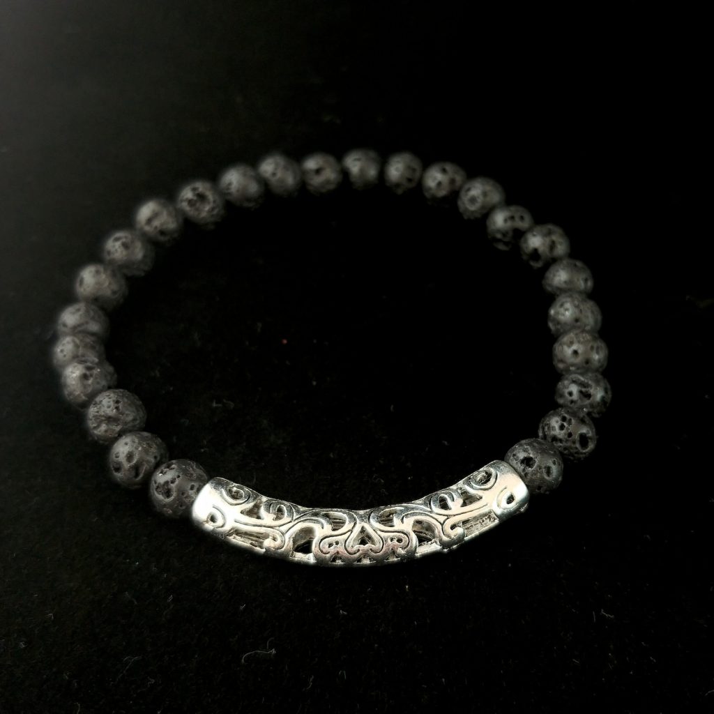 A zoomed in shot of a lava bracelet: it is made of dark black beads.