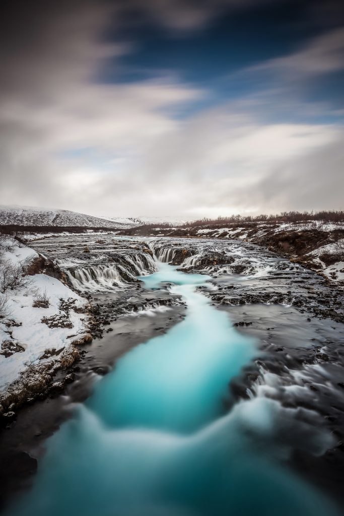 Bruarfoss is one of the best places to visit in Iceland with its vibrant blue flowing water