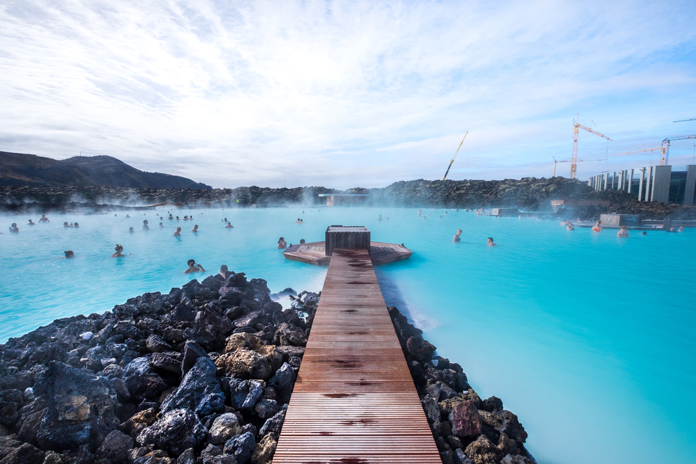 The beautiful water of the Blue Lagoon with people soaking.