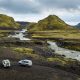 two 4wd vehicles on an F-road by a river in the highlands