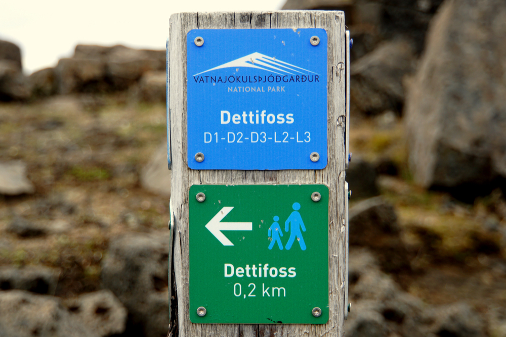 Blue and green trail signs showing the directions to walk to see Vatnajökulsþjódgardur national park’s waterfall Dettifoss and Selfoss