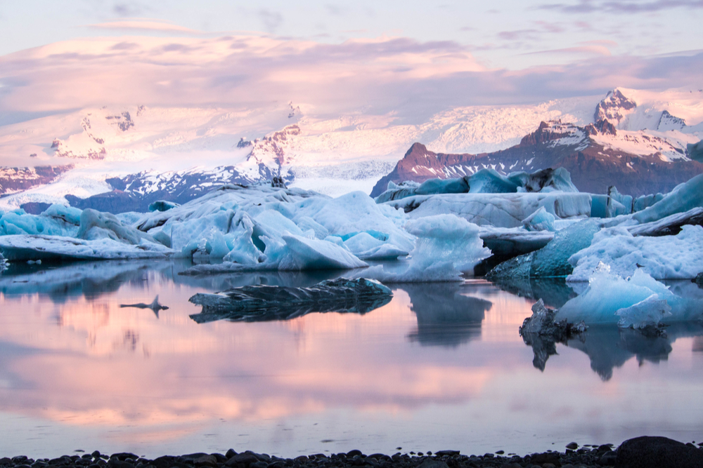 Pink and purple dreamy skies over blue Jökulsárlón glacier lagoon is where James Bond movies filmed in Iceland 