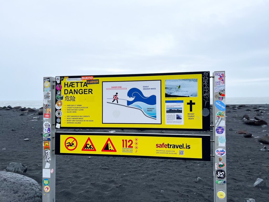 Warning sign on reynisfjara black sand beach that shows how easily sneaker waves can drag you far out to sea with the current

