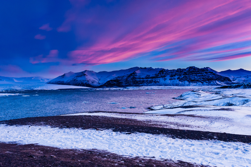  Jökulsárlón glacier lake taken at blue hour the lake and mountinas are visible and the sky is blue and pink 