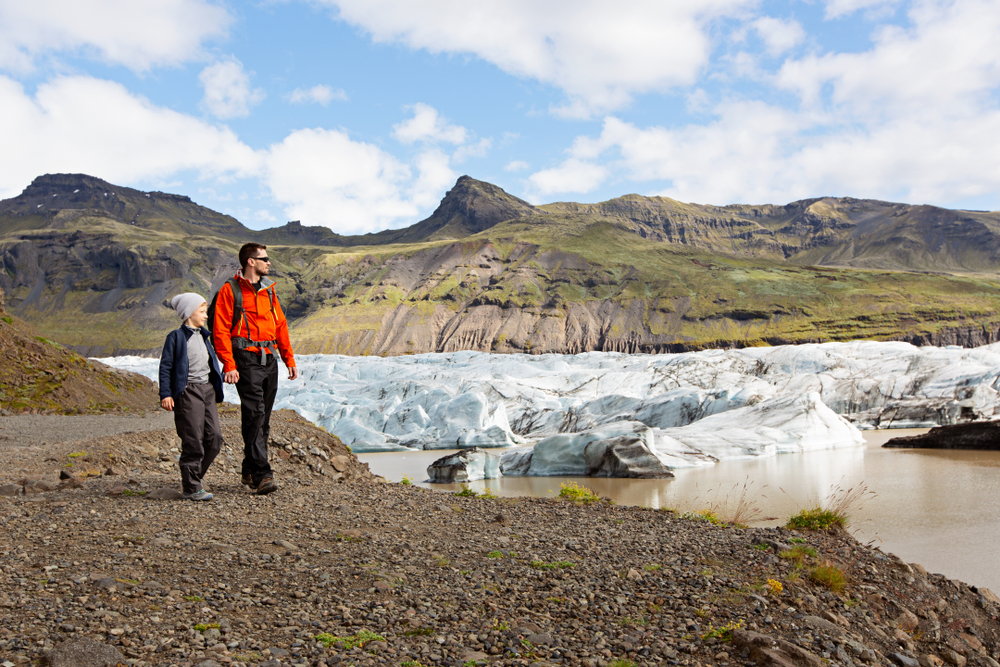 family, father and son, enjoying beautiful hike at glacier in skaftafell national park in iceland. One of the things to do in Iceland with kids