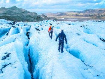 people hiking on a glacier in the south coast of iceland