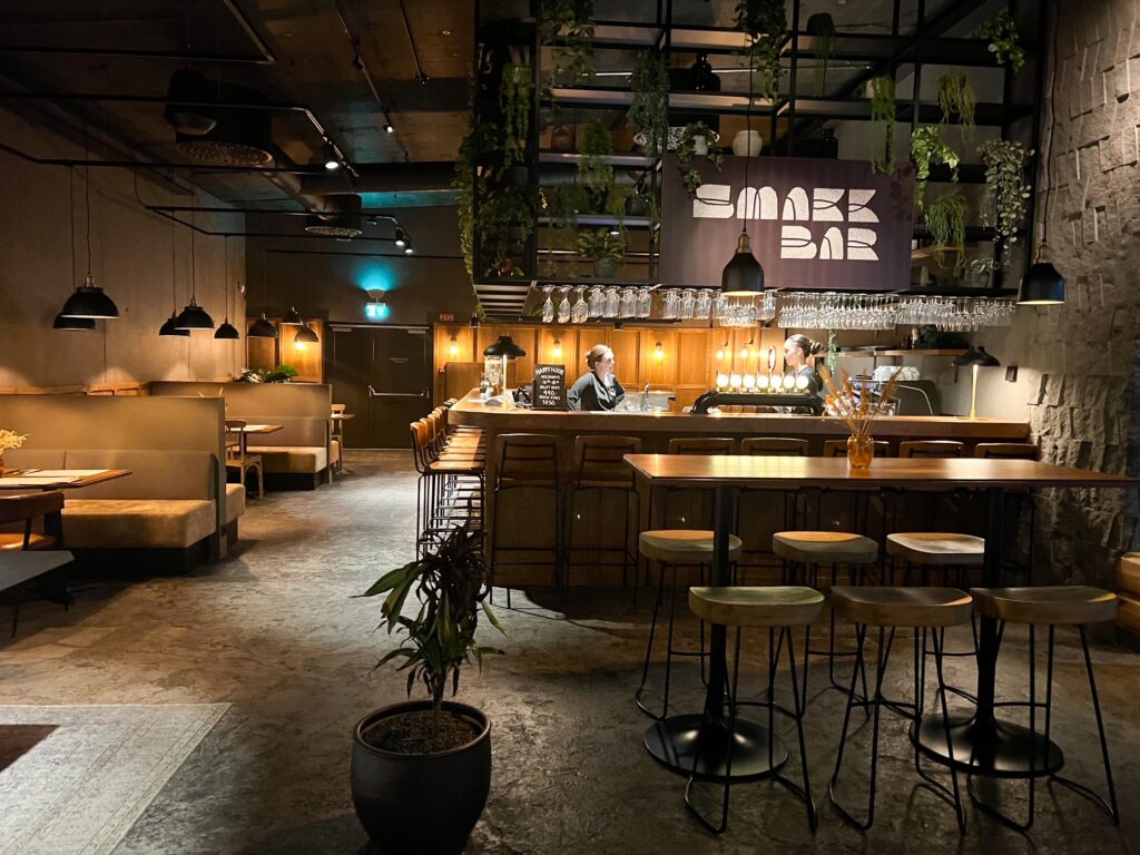 Dining can happen at the rustically decorated Smakk bar with concrete wood and plants