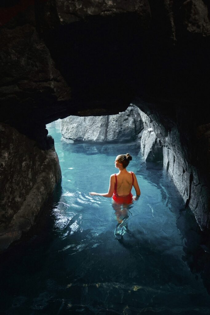 a girl in red bathing suit entering the Sky lagoon