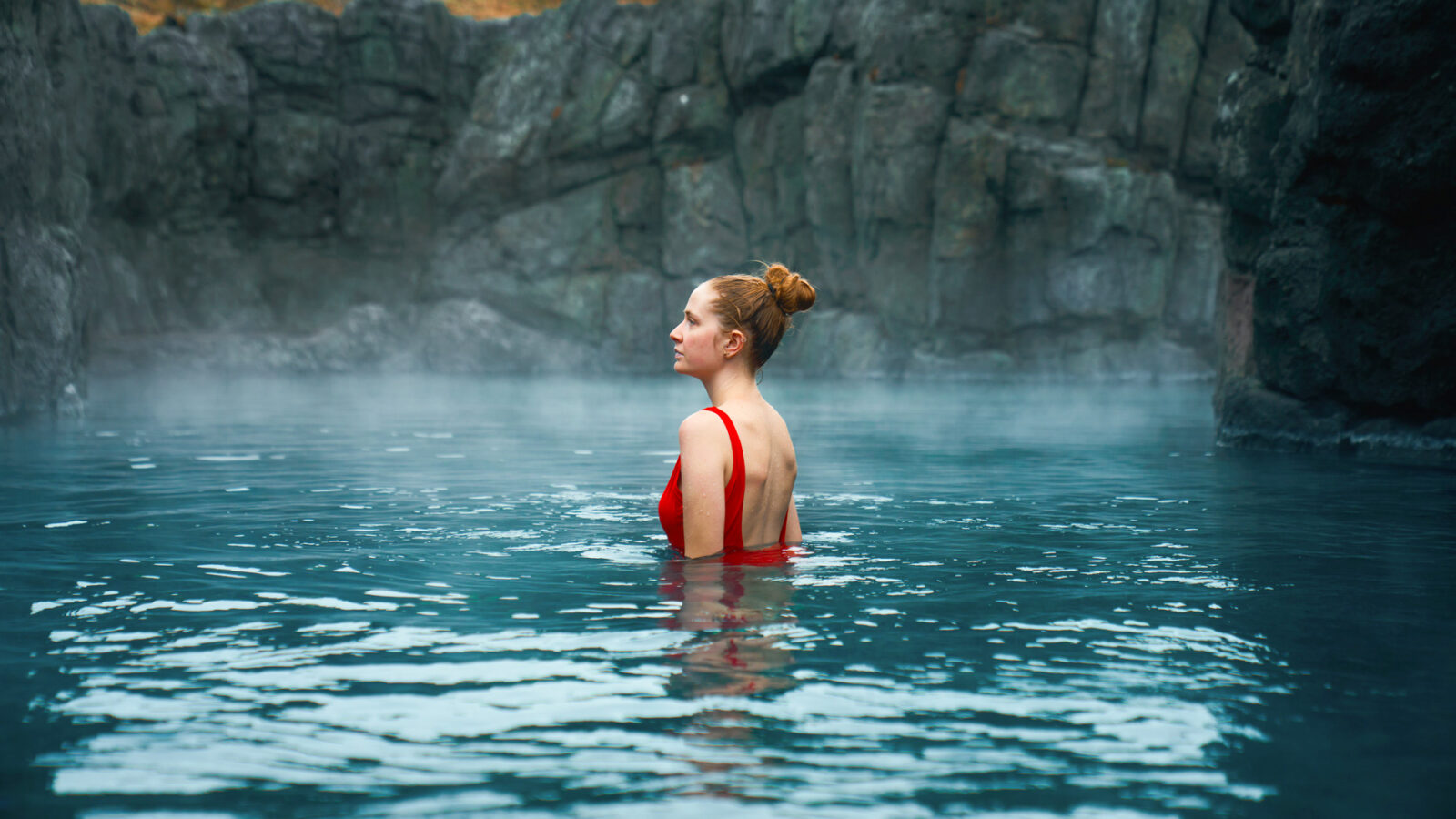 woman standing in front of sky lagoon in iceland