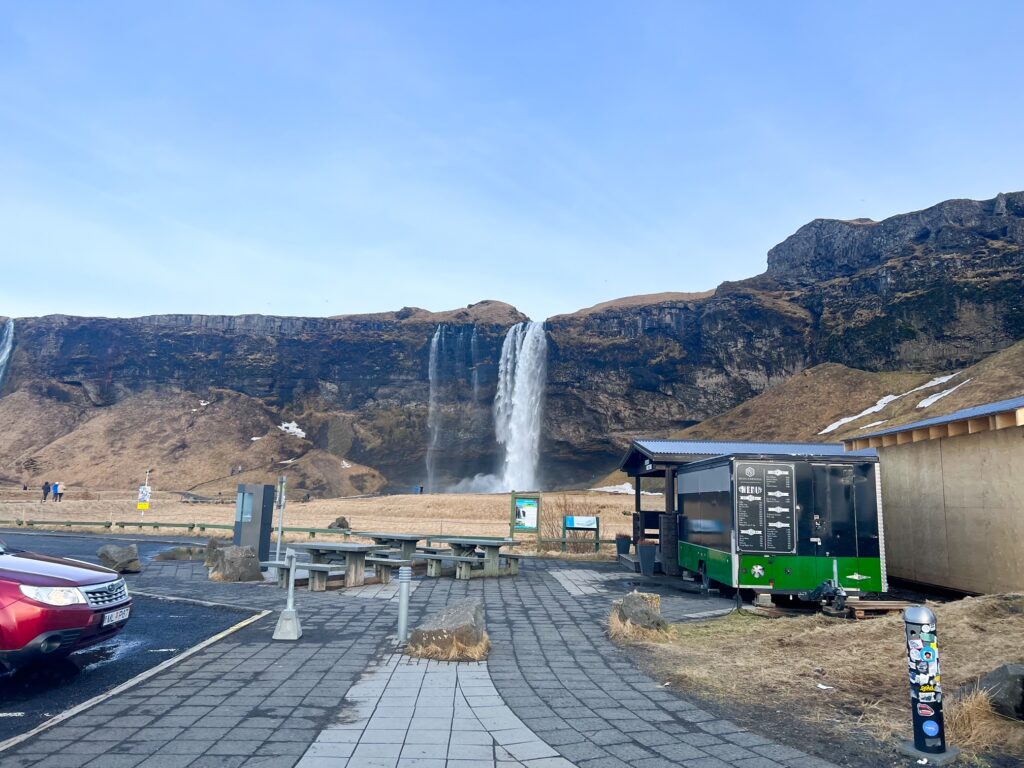 The view of the Seljalandsfoss waterfall as you can see it from the parking lot during winter. 