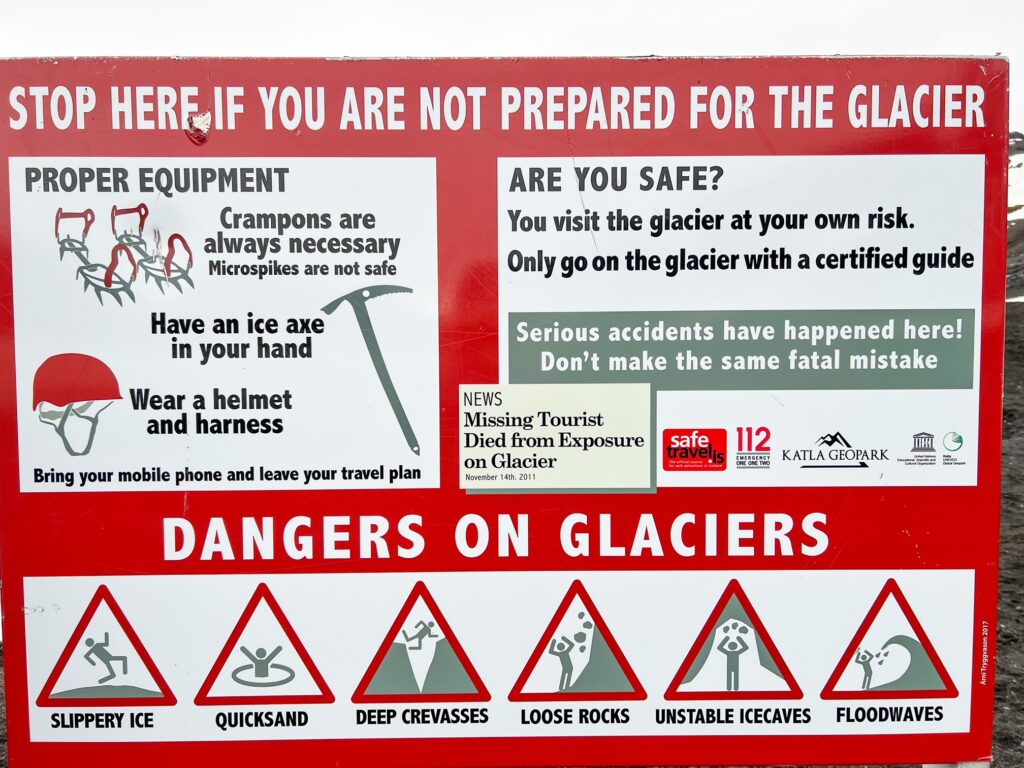 large warning sign prepares hikers to not attempt Solheimajokull glacier without a guide as there are many precautions that need to be taken in order to hike the ice cap