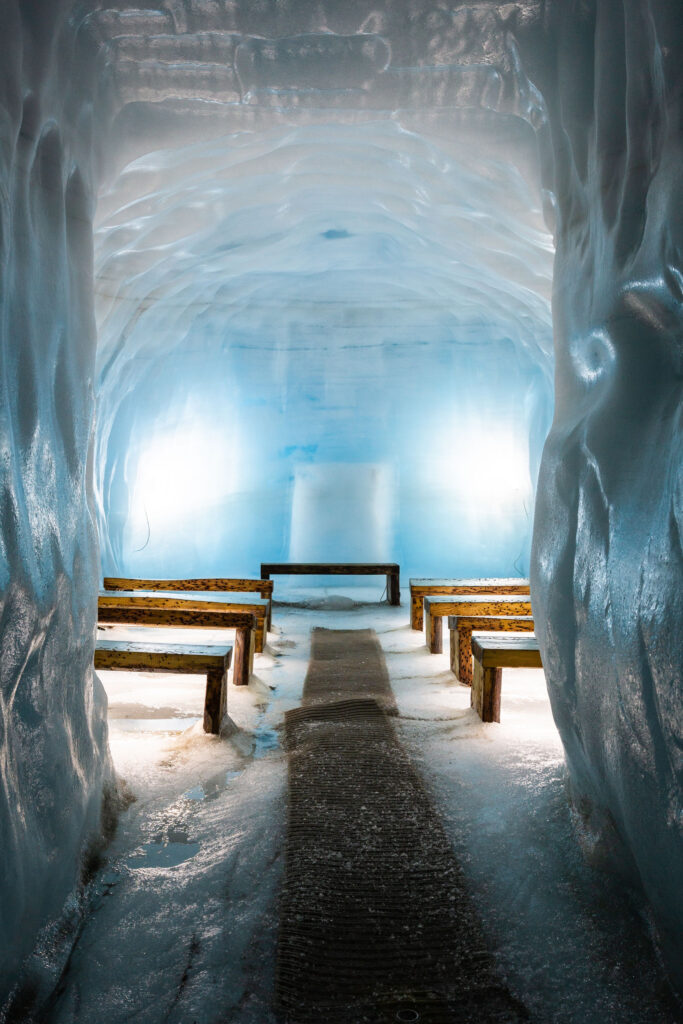Wooden benches fill the smooth blue walled chapel room of the only manmade glacier cave in Iceland