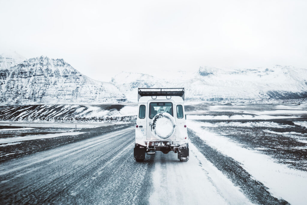 On a snowy winter day in Iceland, a defender drives toward the mountains