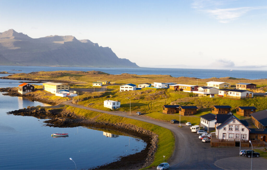 Colorful town on a small peninsula on Iceland’s east coast surrounded by calm blue water 