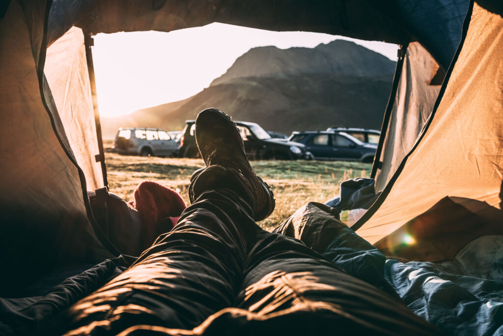 Person tent camping at iceland camper van sites near large mountains