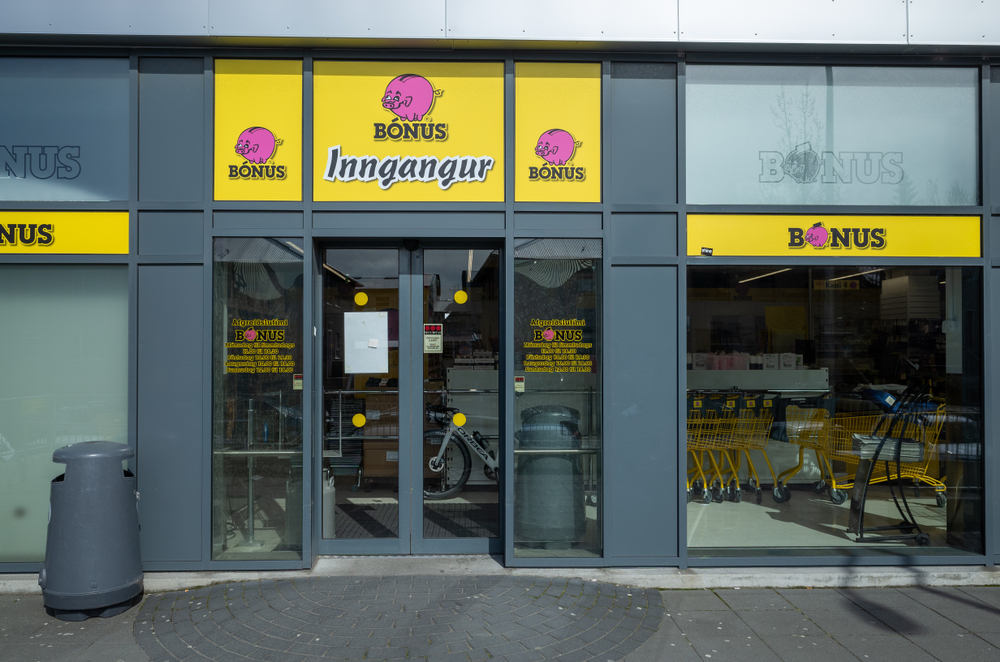 the front of a Bonus grocery store with the pink pig logo and yellow background