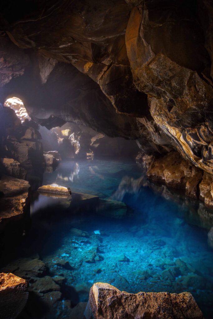 the clear, brilliant blue waters of the hot spring in the Grjotagja lava cave