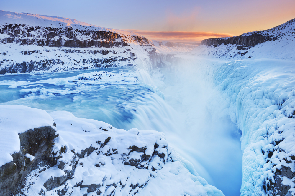 Gullfoss Waterfall partially frozen in the winter with snow surrounding it