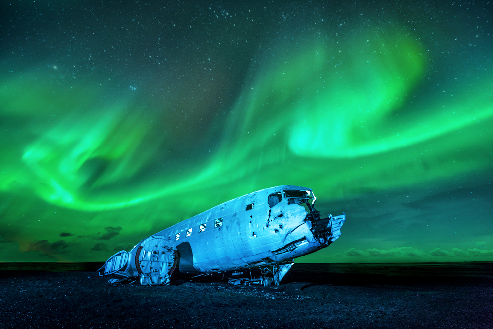 the Northern Lights over the plane crash on the Solheimasandur black sand beach