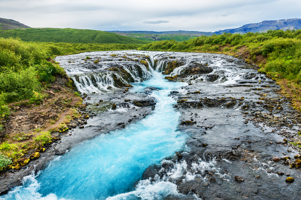 The short Bruarfoss waterfall with vivid blue colors.