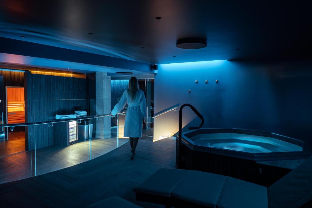 Picture of hotel spa showing a wman in a bathrobe walking away from the hot tub. The article is about where to stay on the Golden Circle. 