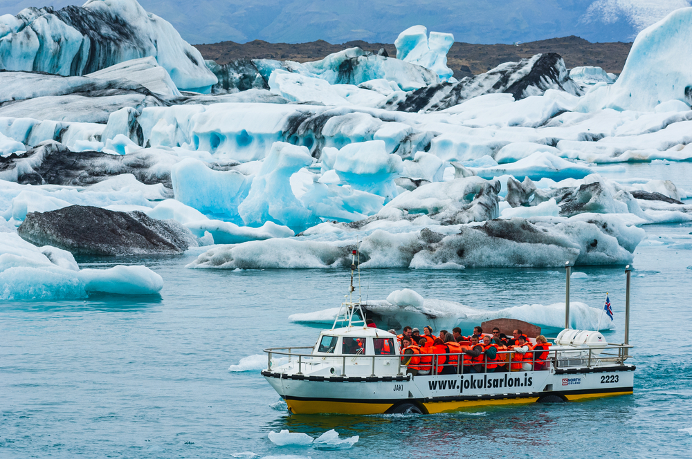 People in a tour boat in the Jökulsárlón Glacier Lagoon with many icebergs.