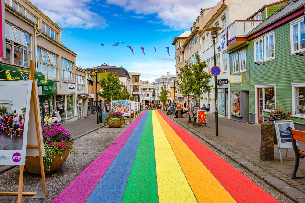 Rainbow painted pedestrian road in downtown Reykjavik with shops.