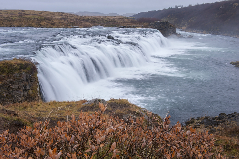 the short, but wide Faxafoss waterfall streaming down on a gloomy day