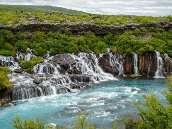 the many cascades of Hraunfossar Waterfall flowing into the turquoise Hvita River
