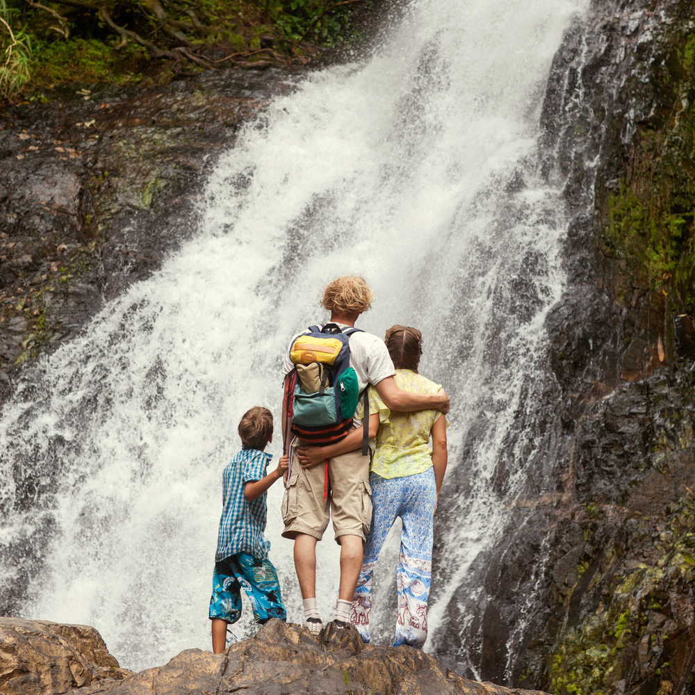 A couple with their child enjoy summer views in Iceland, their cotton clothes comfortable since they knew what to wear in Iceland for kids.